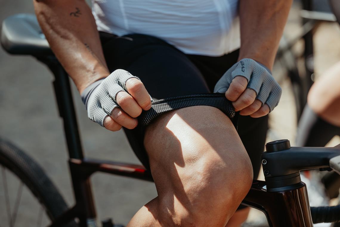 Mężczyzna poprawia spodenki przed jazdą rowerową.