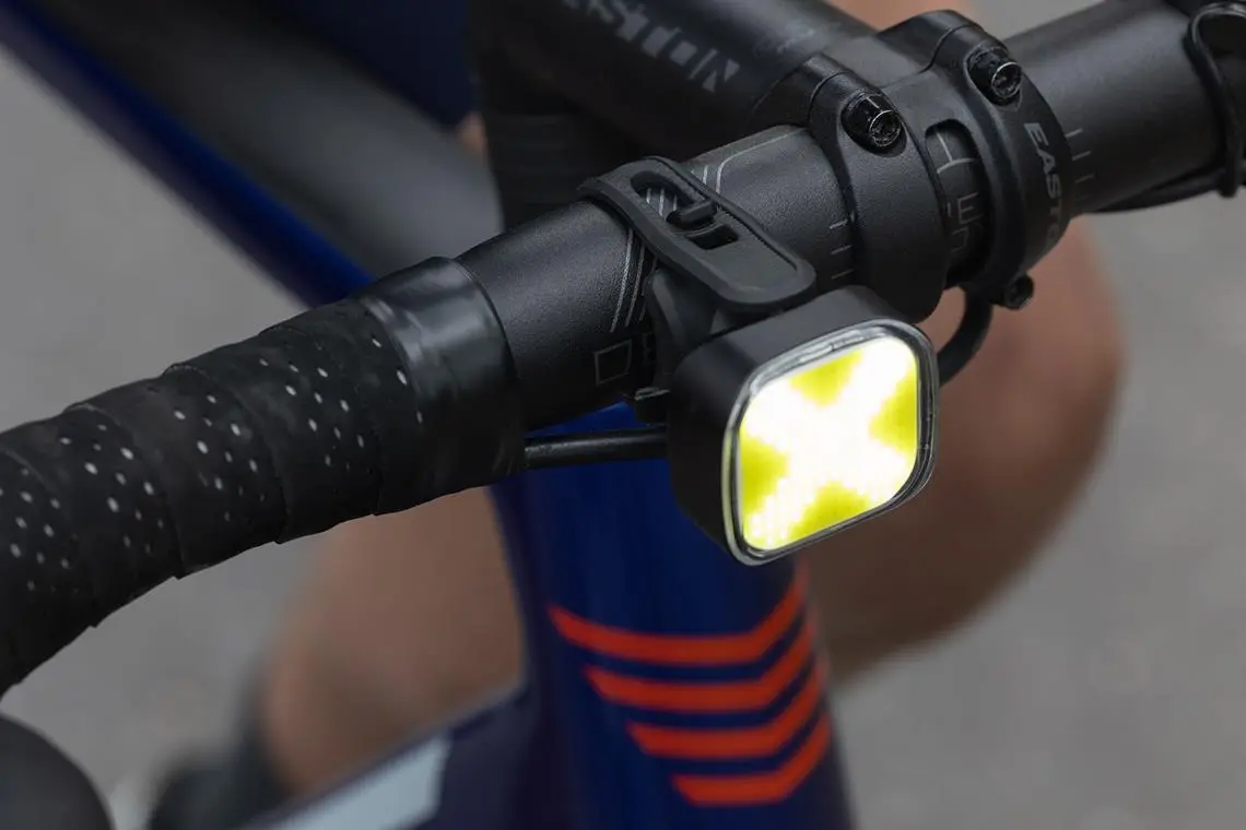 Przednia lampka Eyen Glow PRO na kierownicy, tuż przy mostku.