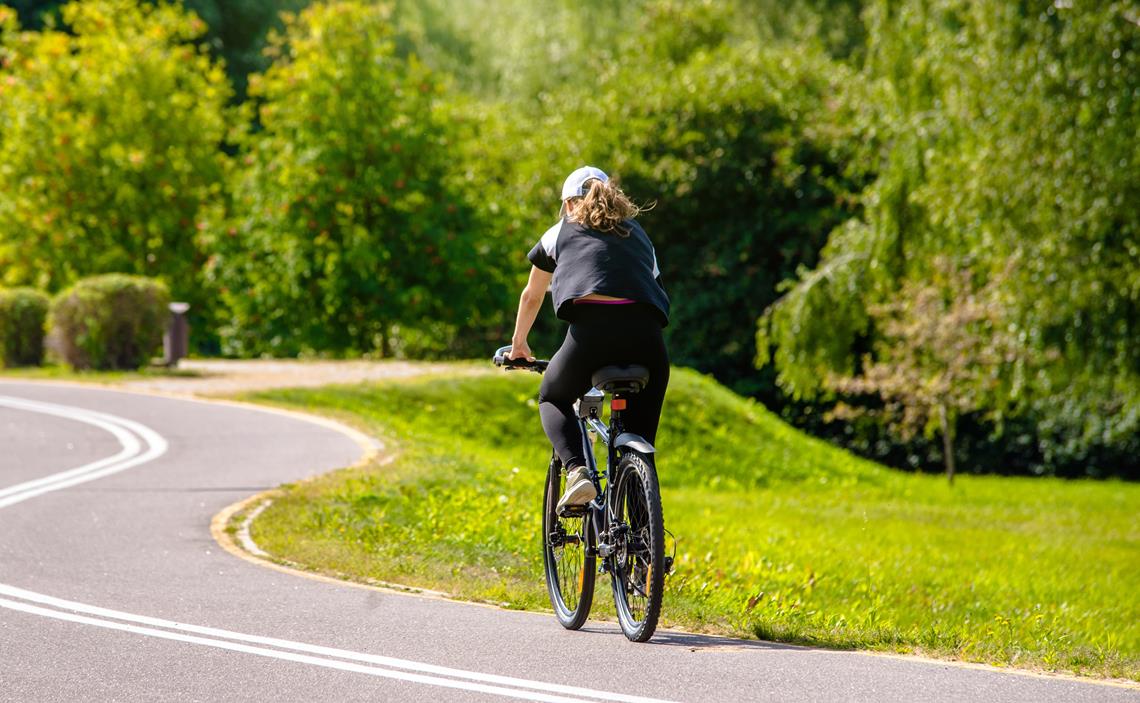Kobieta jadąca na rowerze w parku