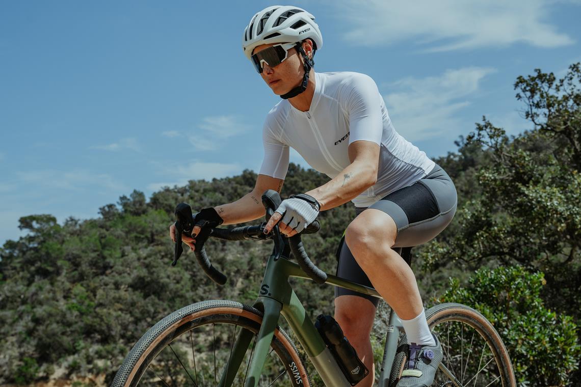 Kolarska jedzie na gravelu w hiszpańskim lesie.