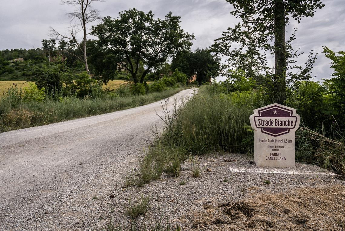 Strade Bianche z widokiem na znak Monte Sante Marie